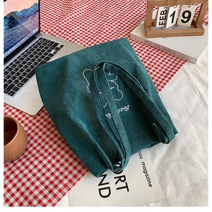 Dettaglio borsa shopper in velluto a coste verde scuro con ricamo di orso su panno