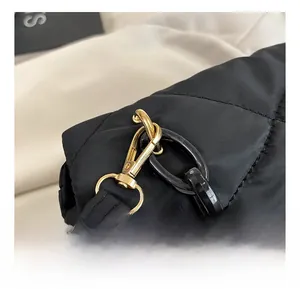 Close-up of premium gold metal hooks and black acrylic chain on quilted crossbody bag