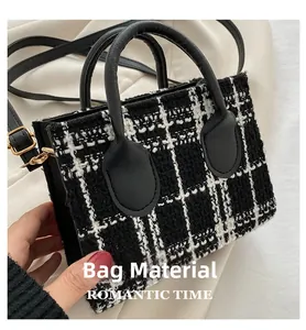 Gros plan du sac à main en tweed noir et blanc avec poignée en cuir et boucles en métal
