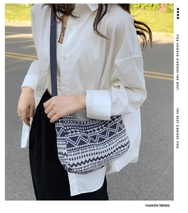 Detail of geometric woven pattern on blue ethnic crossbody bag with canvas strap