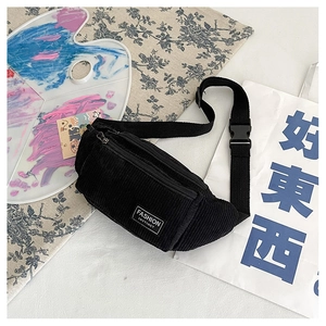 Detail of black corduroy waist bag with adjustable strap and Fashion Instinct patch