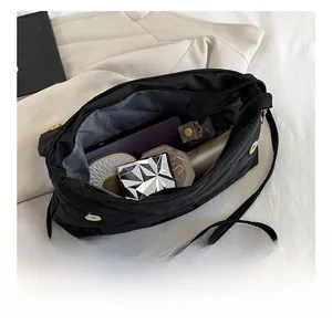 Interior view of black quilted crossbody bag showing spacious capacity for cosmetics