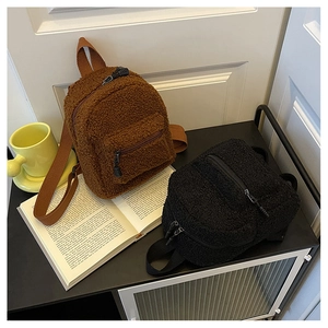 Detail of plush lamb wool mini backpacks in brown and black with soft teddy fur texture