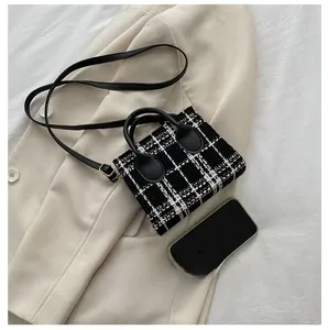 Vue détaillée du mini sac en tweed à carreaux noir et blanc avec anse en cuir