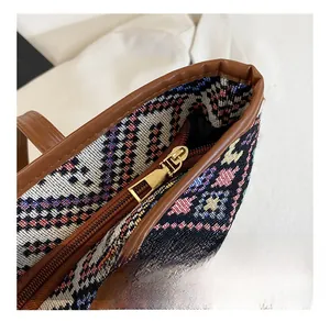 Detailed close-up of smooth gold metal zipper and ethnic woven fabric on tote bag