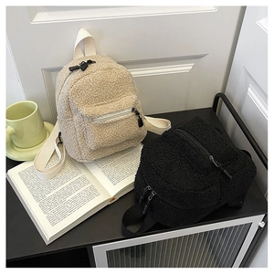 Detail showing plush faux shearling backpacks in beige and black colors on shelf