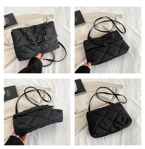 Detailed view of black quilted nylon crossbody bag with resin chain and adjustable straps