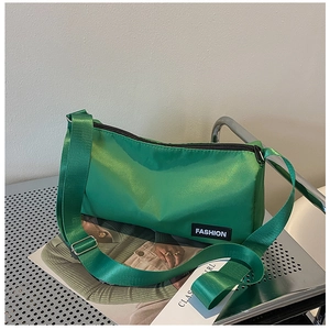 Détail du sac bandoulière en nylon vert avec sangle réglable et étiquette mode