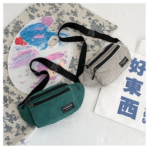 Detail showing green and light gray corduroy waist bags with fashion textile labels
