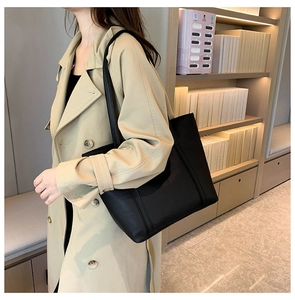 Chic black PU leather tote bag shown with model in stylish office commute setting