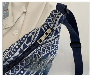 Détail d'un sac bandoulière en toile tissée avec motif géométrique et fermeture éclair en métal