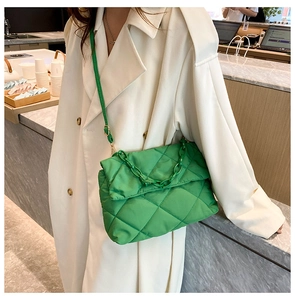 Close-up of bright green quilted nylon crossbody bag with matching chain and shoulder strap