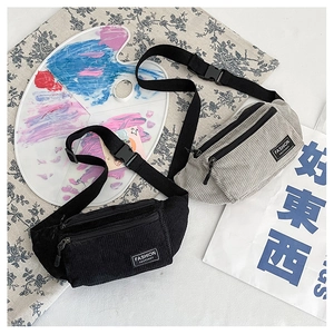 Detail of corduroy waist bags in black and grey with adjustable nylon straps
