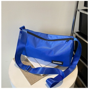 Gros plan sur le sac à bandoulière en nylon bleu vif avec logo et fermeture zippée