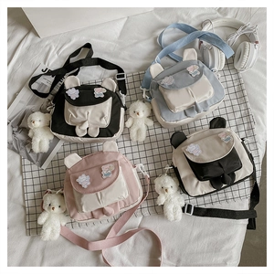 Flat lay of colorful cartoon bunny ear crossbody bags with plush bear charms
