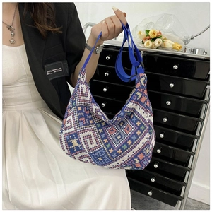 Detail of colorful geometric woven crossbody bag with adjustable blue nylon shoulder strap