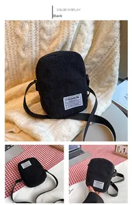 Detail of black corduroy crossbody bag with zipper and adjustable strap hardware