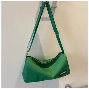 Gros plan du sac bandoulière en nylon vert avec étiquette mode et fermeture éclair