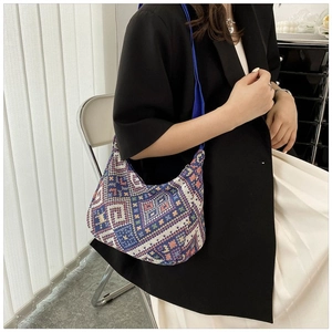 Close-up of a colorful geometric pattern hobo bag with royal blue shoulder strap