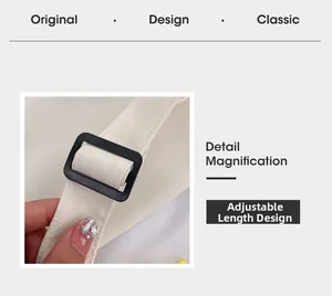 Détail d'une bandoulière réglable avec boucle noire sur un sac à main minimaliste