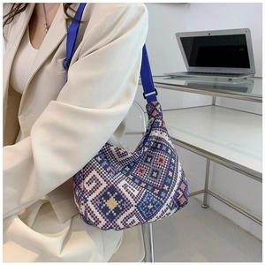 Close-up of geometric woven fabric shoulder bag with retro ethnic patterns and blue strap