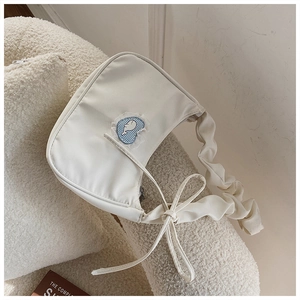 Detailansicht der cremefarbenen Nylon-Schultertasche mit gerafften Trägern und Herzpatch