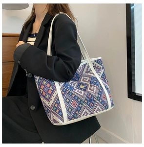 Détail du cabas tissé ethnique avec motifs colorés et anses en cuir blanc pour femme