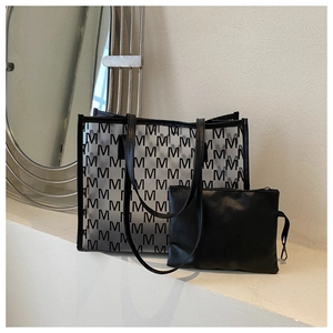 Detail of trendy black PU tote bag set with 'M' pattern and removable inner pouch