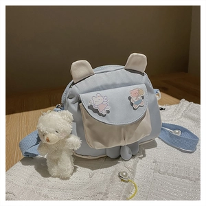 Detail of cute rabbit ear crossbody bag with plush bear charm and cartoon patches