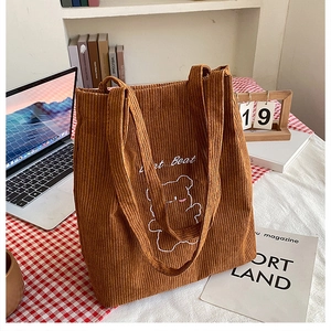 Dettaglio borsa tote in velluto a coste marrone con ricamo di orso e scritta Heart Beat