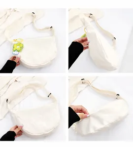 Vues détaillées d'un sac demi-lune en toile blanche avec bandoulière et breloque fleur