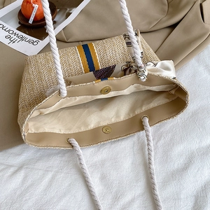 Japanese woven straw tote bag with rope handles and colorful stripes shown from above