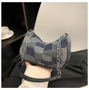 Close-up of hobo shoulder bag with patchwork denim fabric and silver chain strap details