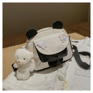 Detail of panda canvas crossbody bag featuring cute animal patches and a plush bear charm
