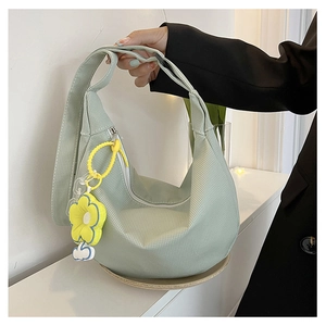 Détail du sac demi-lune en velours côtelé vert menthe avec pendentif tournesol et bandoulière