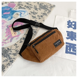 Detail view of brown corduroy belt bag featuring a double zipper and fashion label