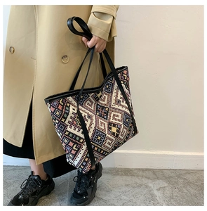 Détail d'un sac cabas bohème tissé géométrique avec des bandoulières en cuir noir
