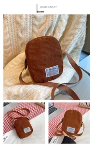 Close-up of brown corduroy crossbody phone bag featuring a white woven patch and fabric strap