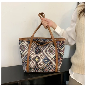 Détail d'un sac cabas ethnique aux motifs géométriques colorés et anses en cuir PU