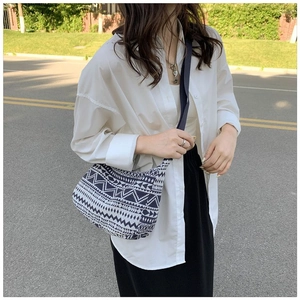 Détail du tissu tissé géométrique bleu et blanc d'un sac bandoulière ethnique chic