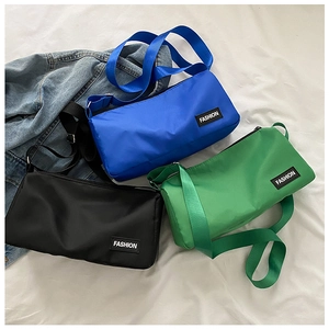 Sacs bandoulière cylindriques en nylon bleu, vert et noir avec étiquette de mode