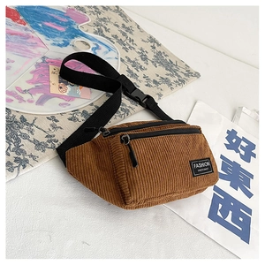 Detailed close-up of brown corduroy chest bag featuring textured fabric and dual zippers