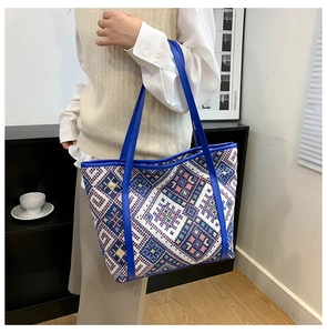 Detailed shot of large ethnic tote bag featuring geometric patterns and leather handles
