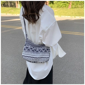 Vue arrière en extérieur d'un grand sac cabas en toile géométrique avec bandoulière