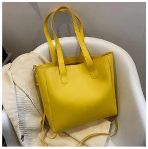 Detail of yellow matte PU leather tote bag with sturdy straps and fine stitching
