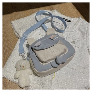 Detail of cute rabbit ear crossbody bag with plush bear charm and adjustable strap