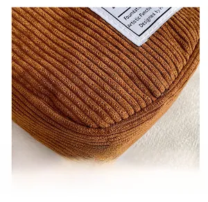 Macro detail of brown corduroy bag fabric texture showing vertical stripes and woven label