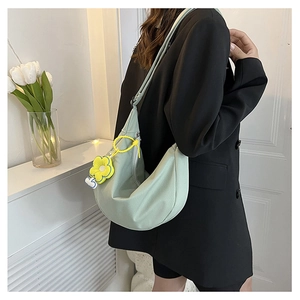 Détail du sac bandoulière en velours côtelé vert menthe avec pendentif fleur jaune