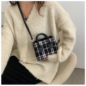 Détail d'un mini sac en tweed à carreaux avec poignée en cuir et métal doré
