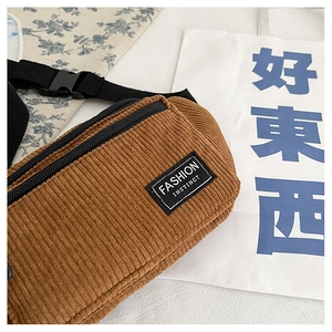 Detailed texture of brown corduroy chest bag with adjustable strap and fashion label